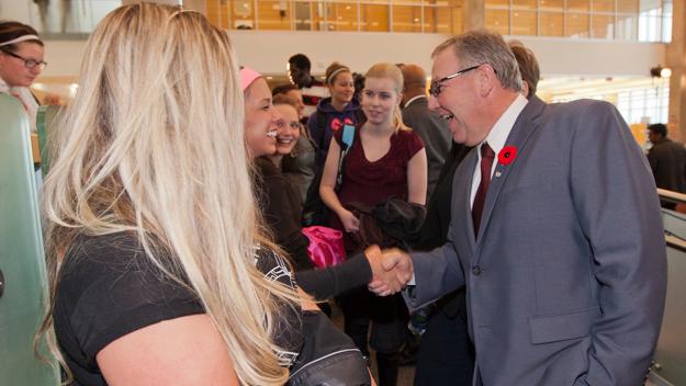 Premier Darrell Dexter smiles as he shakes hands with a student during a chat after the announcement.