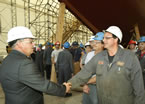 Premier Darrell Dexter shakes hands while chatting with staff at Lunenburg Shipyard.