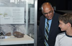 Leonard Preyra, Minister of Communities, Culture and Heritage, and Thomas Keating, a member of the family who found the fossils, look at the 'Superstar' display.