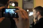 A cellphone is used to record a video during the event to announce fairness in cellphone contracts.