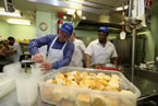 Premier Darrell Dexter helps Matt Jordan  prepare meals for Meals on Wheels.