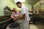 Minister of Seniors Denise Peterson-Rafuse helps Shawn Morton peel potatoes.