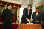 Tracey Dorrington-Skinner of VOICES and Minister of Communities, Culture and Heritage Tony Ince look on as Premier McNeil lights a candle as part of the formal apology.