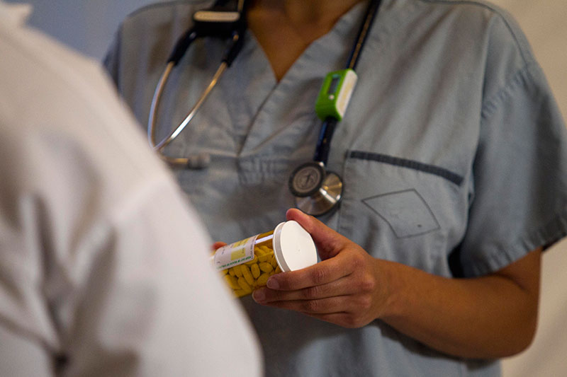 Healthcare worker holding a prescription speaking to a patient