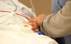 An emergency room nurse holds the hand of a patient under his care in the emergency room at the QEII Infirmary site.