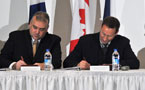 Communities, Culture and Heritage Minister Dave Wilson (left) and National Defence Minister Peter MacKay sign documents supporting Grand Pré bid to become a UNESCO World Heritage Site.