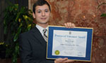 Simon Dugas holds his certificate after being named the Youth Volunteer of the Year.