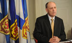 Finance Minister Graham Steele listens to a question from the media during a briefing.