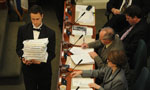 A page carries a stack of budget documents in Province House.