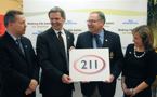 Alan Richardson, Nova Scotia Power Inc., Chuck Hartlen, Bell Aliant, Premier Darrell Dexter and Catherine Woodman, United Way, hold a 2-1-1 sign.