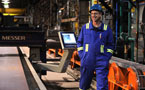 A DSTN worker smiles during the grand opening ceremony while walking trough the Trenton plant.