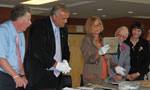 Director or Archives Management at Nova Scotia Archives Margaret Campbell looks at a report from the time capsule as the head table guests look on.