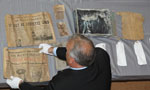 Communities, Culture and Heritage Minister David Wilson spreads out the contents of the time capsule placed during the construction of Queen Elizabeth High School in 1941.