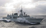 A Canadian Navy frigate, built by Irving Shipyard, slices through the ocean.