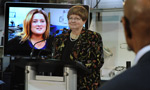 Labour and Advanced Education Minister Marilyn More stands in front of a video of Virginia King talking about the great jobs available in the trades while Economic and Rural Development and Tourism Minister Percy Paris looks on.