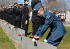 A young cadet places a rose on the headstone of one of the Titanic gravesites during the Titanic Spiritual Ceremony at the Fairview Lawn Cemetery.