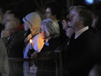 Spectators gather, holding candles.