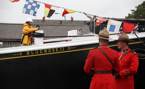 A line is secured to Bluenose II for the relaunch as two RCMP offers stand in the foreground.
