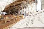 The designs for the BluenoseII renovation on a table in front of the schooner.
