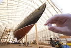 A Canadian dime is held in front of the sailing icon.