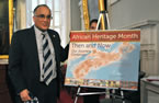 Communities, Culture and Heritage Minister Leonard Preyra stand beside this year's African Heritage Month poster that was unveiled at the launch.