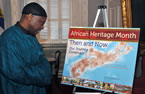 Wayn Hamilton, CEO of African Nova Scotian Affairs, looks at this year's poster, which celebrates the theme Then and Now, Our Journey Continues.