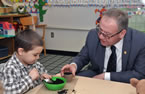 Premier Darrell Dexter holds a small planting pot as Kayden Lethbridge fills it with soil during an Early Years announcement Rockingstone Heights School.