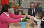 Education and Early Childhood Development Minister Ramona Jennex plays pattycake with Starlynn Myra-Misener as Kyra Gray-Benedict and Premier Darrell Dexter watch.