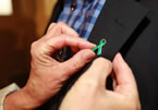 Lucille Harper, Antigonish Women's Resource Centre, attaches a pin representing Sexual Assault Awareness Month to to Premier Darrell Dexter's lapel.
