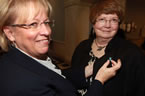 Stephanie MacInnis-Langley, executive director of the Status of Women, attaches a pin to Status of Women Minister Marilyn More.