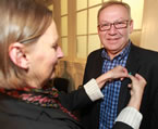 Lucille Harper, of the Antigonish Women's Resource Centre, pins a symbol of Sexual Assault Awareness Month onto Premier Darrell Dexter.