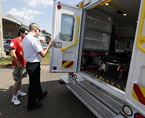 Two paramedics look over a new ambulance.