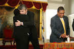 Ms. Dorrington-Skinner and Premier McNeil embrace as Mr. Ince lights a candle during the ceremony.