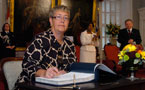 Cynthia Baker takes part in the ceremony on behalf of her husband Michael Baker.