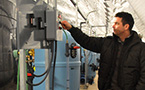Kirk Havercroft of Sustainable Fish Farming Canada Ltd. checks a panel beside one of the fish tanks.