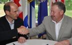 Premier Darrell Dexter and Maine Governor John Baldacci shake hands after signing a Memorandum of Understanding on energy co-operation.