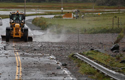 A grader clears debris caused by Hurricane Bill near Lawrenceton Beach.
